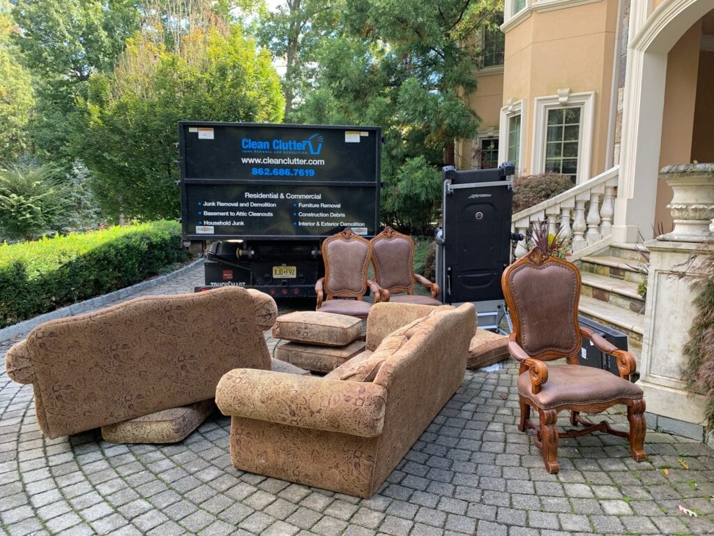 Clean Clutter truck with furniture staged for removal at residential property